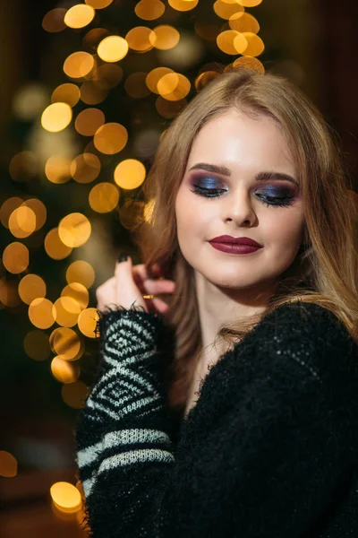 美丽的年轻女子在圣诞树附近。圣诞节的气氛。女孩与时尚化妆 — 图库照片