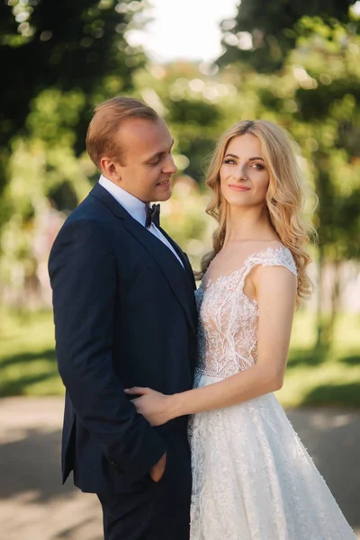 Feliz pareja joven en el día de su boda pasar tiempo en el parque. Fondo verde — Foto de Stock