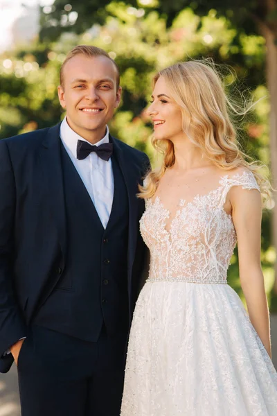 Feliz pareja joven en el día de su boda pasar tiempo en el parque. Fondo verde — Foto de Stock