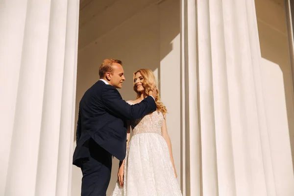 Casamento na Grécia. Um casal olha um para o outro e sorri. Loira cabelo noiva se apaixonar — Fotografia de Stock