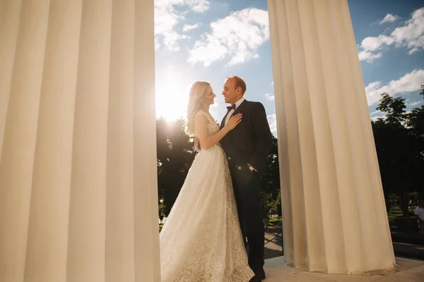 Casamento na Grécia. noivo e noiva ficar perto da grande coluna — Fotografia de Stock