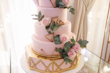 Güzel düğün pastası çiçeklerle süslenmiş. Pasta pembe rengi. Toz gül