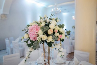 Düğün buketi restoranda masanın üstünde. Pembe ve beyaz çiçekler. Gül ve ortanca