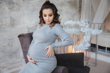 Güzel Abiye şık hamile modelinde de koltuğa otur. Arka yatak odası.