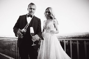 Evlilik çift şehir ve İçecek şampanya bardağı üzerinden arka plan üzerinde durmak. Siyah beyaz resim