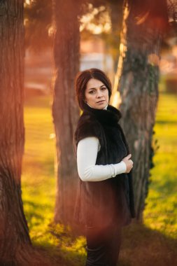 Koyu saçlı kadın ağacın önünde dur. Bob saç kesimi kadın vardır
