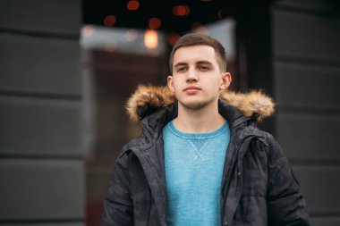 Gri ceketli adamı sokakta duran ve bir fotoğrafçı için poz