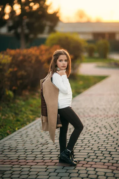Malá procházka v parku zlatý podzim. Ona drží kabát a představuje fotografa — Stock fotografie