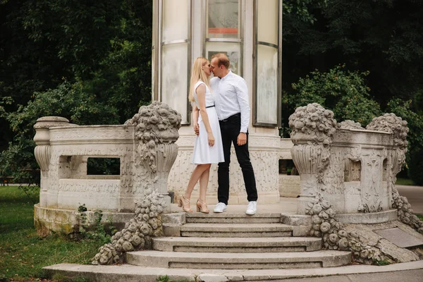 Schöne cuple stehen auf der Treppe und umarmen einander. Mann und Frau gehen im Park spazieren. Liebesspiel — Stockfoto