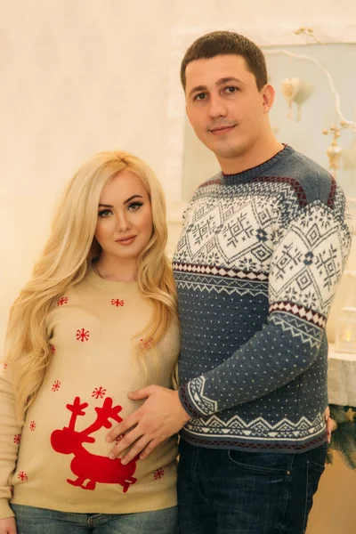 Glückliches Paar in Urlaubsstimmung. Yong fieberhaft in schönen Strickpullovern in Vorfreude auf die Weihnachtsfeiertage — Stockfoto