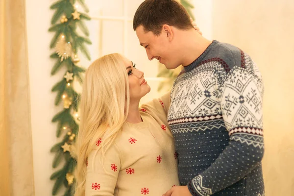 Um casal feliz em espírito natalício. Yong fimily em belos blusas de malha em antecipação de férias de Natal — Fotografia de Stock