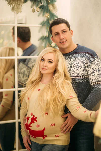 Ein glückliches Paar steht zur Weihnachtszeit vor dem Spiegel. Feiertagsstimmung — Stockfoto