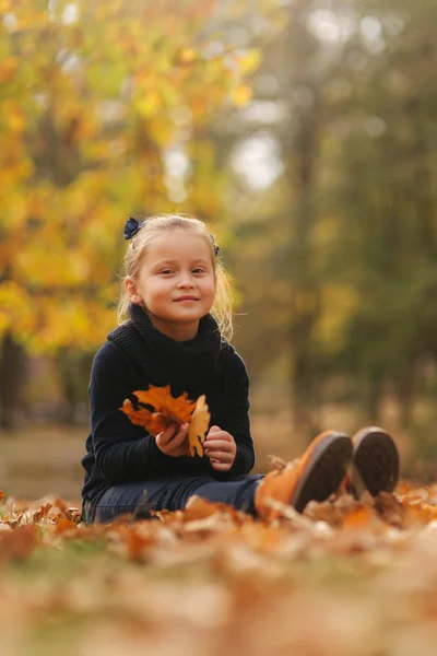 아름 다운 젊은 여 자가 최근 예약에 나뭇잎과 그들을 던졌습니다. 화려한 배경입니다. 행복 한 어린 소녀 웃음과 재미 — 스톡 사진