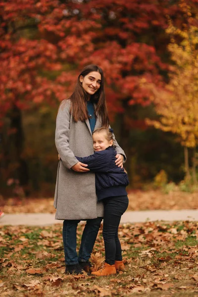 Due sorelle passeggiano nel parco in autunno. L'infanzia. stagione e la gente consept-felice famiglia — Foto Stock