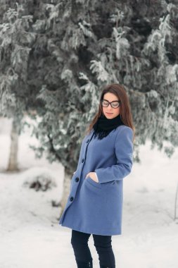 Kış ceket renk mavi kobalt ve siyah atkı siyah gözlük güzel mutlu genç kadınla kar pul ile kaplı