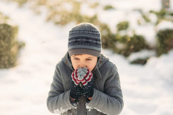 Un ragazzo riscalda le mani dal freddo in inverno — Foto Stock