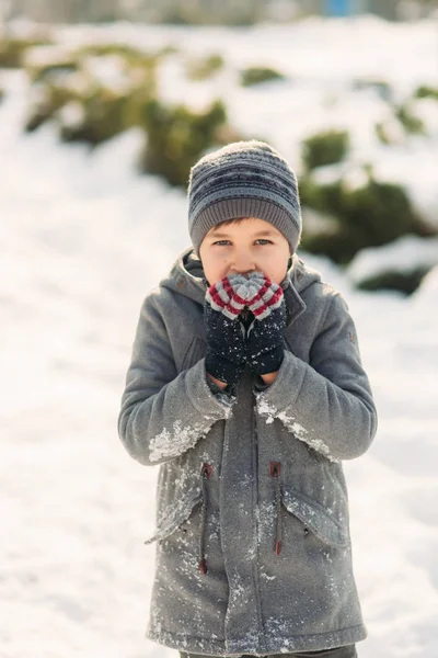 Een jongen verwarmt zijn handen van de kou in de winter — Stockfoto