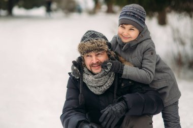 Mutlu baba oğluyla karlı kış hava parkta size yürür