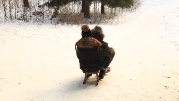 Chłopak i dziewczyna na sankach. Snowy zimowych warunków pogodowych. Szczęśliwa rodzina. Świąteczny nastrój — Wideo stockowe