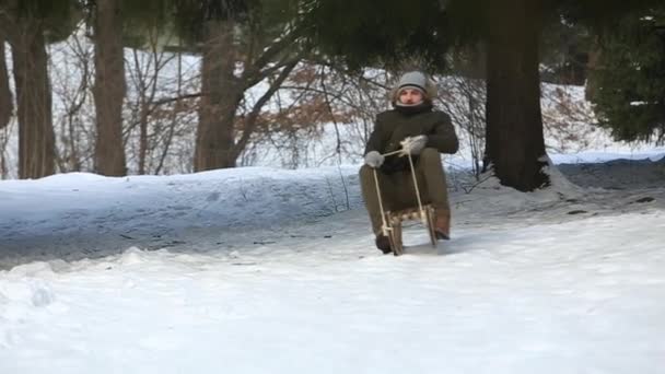 Man in de winter zijn rodelen. Overal sneeuw — Stockvideo