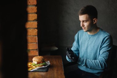 Adam siyah eldiven bir vejetaryen burger onun elinde alır.