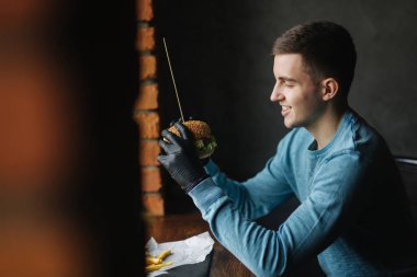 Adam siyah eldiven onun elinde hamburger alır. Sebze vejetaryen burger. Taze sağlıklı gıda