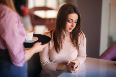 Garson kafede kahve ikram ediyor. kapuçino