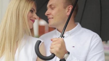 Yakışıklı adam öpücük onun güzel karısı. Beyaz elbiseli güzel kadın kocası sarılmak