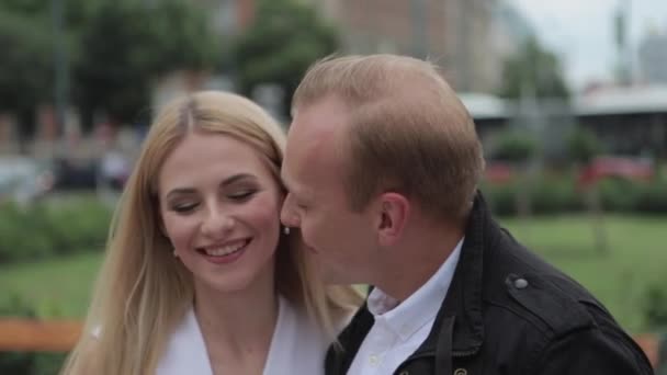 Schöner Mann küsst ihre schöne Frau. schöne Frau im weißen Kleid umarmt ihren Mann — Stockvideo
