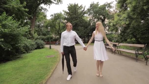 젊은 커플 공원에서 산책. 재미 있고 즐 거 워. 흑인과 백인 옷 — 비디오