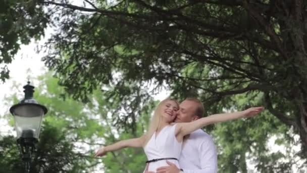 Pareja joven caminando por el parque. Que se diviertan y se regocijan. Ropa en blanco y negro — Vídeos de Stock