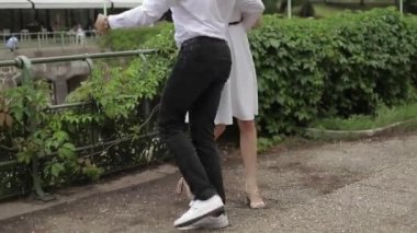 Genç çift parkta yürüyüş. İyi eğlenceler ve sevinirler. Siyah-beyaz elbise