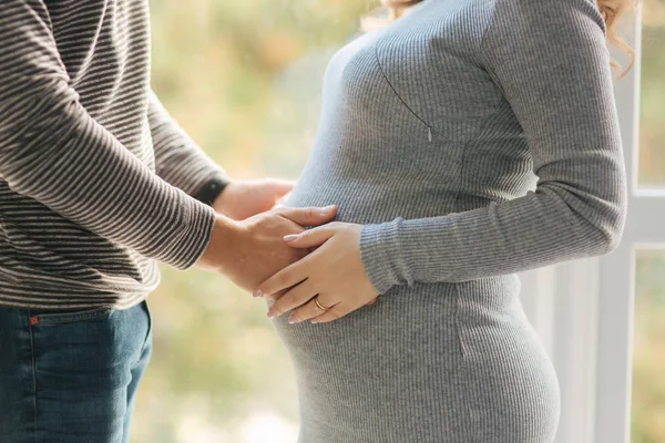 El hombre puso sus manos en el vientre de una mujer embarazada. Vista de cerca — Foto de Stock