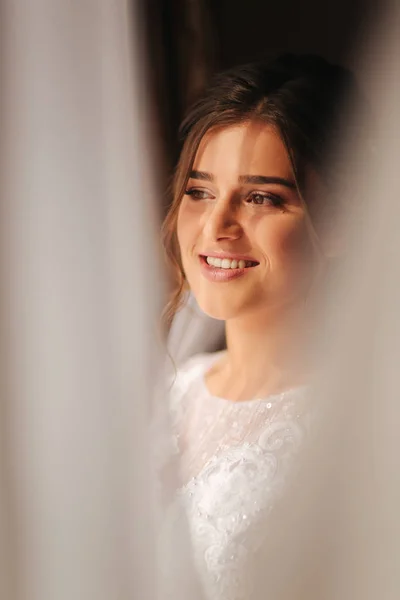 Potret pengantin muda yang cantik. Dia berdiri di dekat jendela di kamarnya — Stok Foto