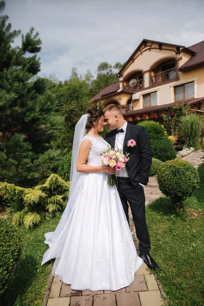 Sposo e sposa passeggiano nel parco il giorno del loro matrimonio. Felice coppia trascorrere del tempo insieme — Foto Stock