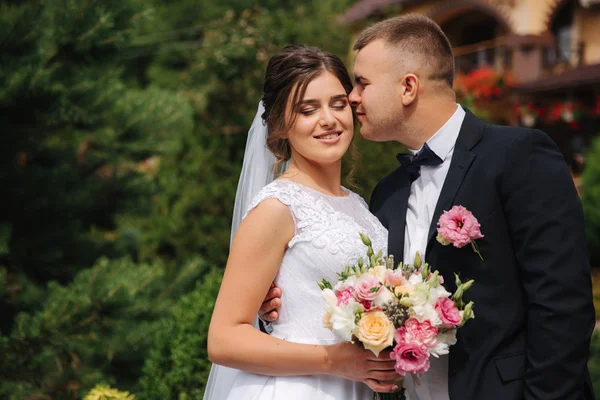 Vackra par på deras bröllopsdag. Porträtt av brudgummen och bruden. Grön bakgrund — Stockfoto
