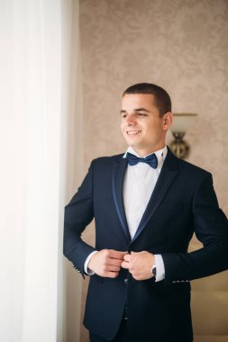Bir düğün günü stand pencerenin yakınındaki yakışıklı damat
