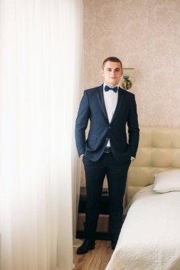 Bir düğün günü stand pencerenin yakınındaki yakışıklı damat