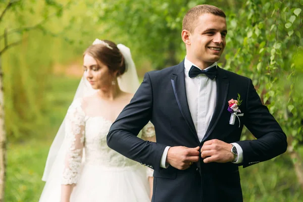 Os recém-casados estão andando no parque no dia do casamento. A noiva e o noivo Desfrutando no dia do casamento — Fotografia de Stock