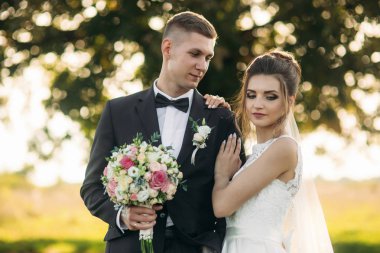 Buket ile onların düğün gününde alanına yürüme mutlu yeni evliler şık birkaç. Tarlanın ortasında ther büyük bir ağaç olduğunu.