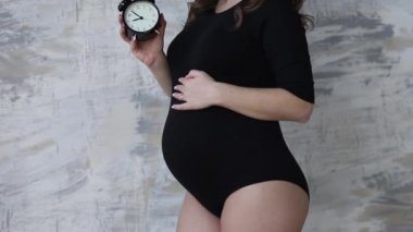 Mutlu gelecekte anne bir zaman değeri. Kadın siyah elbise için bir bebek bekliyor. Gülümseme