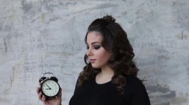 Yound hamile kadın onun elinde bir saat tutun. Gelecekte anne güzel portresi. Bir çocuk için bekleyen kadın bebek