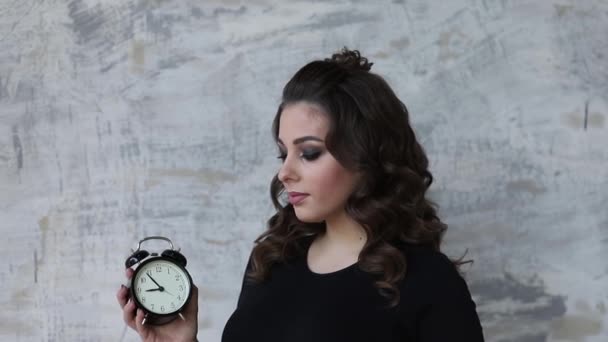 La giovane donna incinta tiene un orologio tra le mani. Bellissimo ritratto della futura madre. Donna in attesa di un bambino, baby — Video Stock