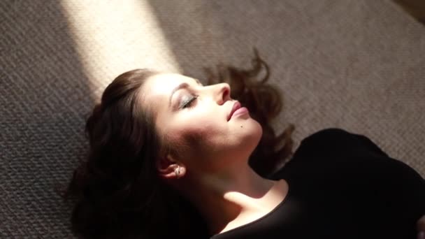 Mladá těhotná žena leží poblíž okna. Sluneční paprsky spadnout na ženu — Stock video