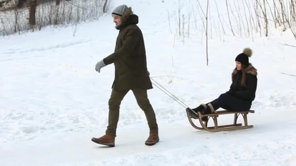 Chlapec a dívka sáňkování. Zasněžené zimní počasí. Šťastná rodina. Vánoční náladu. Muž pomáhá dívka sáňkování — Stock video