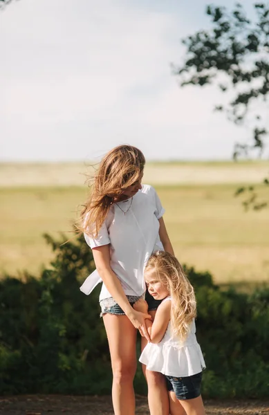 Mother and little daughter walk though the alley and hold each others hands — Stock Photo, Image