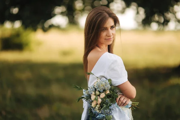 Bela mãe tem buquê de flores e se divertir perto da natureza — Fotografia de Stock