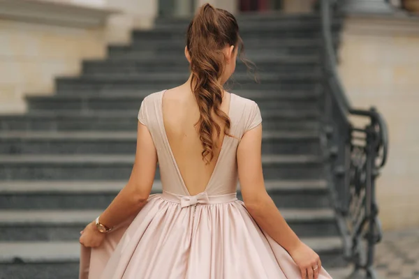 Elegant brunette stand on stairs by the hotel. Fashion model in evening dress — Stock Photo, Image