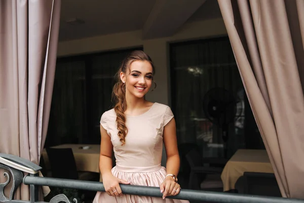 Elegancka brunetka dama stojak na balkon luksusowych i uśmiech. Moda fryzury i makijaż — Zdjęcie stockowe