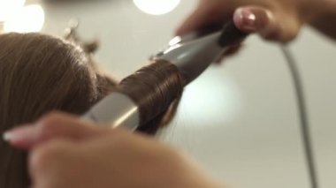 Yakın çekim shot saçlarını Kuaför Salonu doğruldu sahip bir kadın. Saç maşası ağır çekimde vurdu. HD